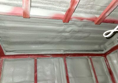 Container ceiling and upper wall fully insulated with spray foam