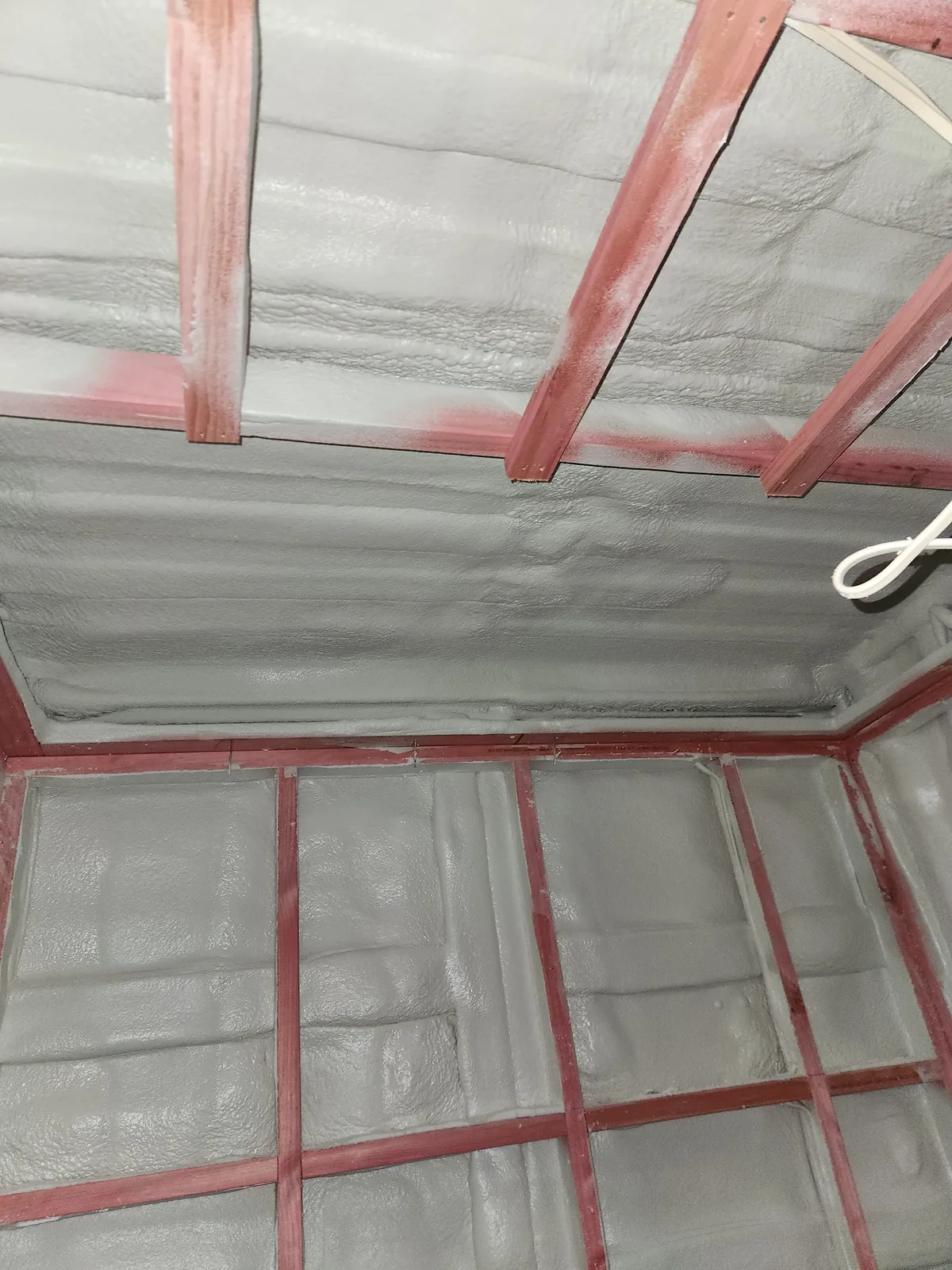 Closed-cell spray foam insulation covering the walls and roof of a shipping container