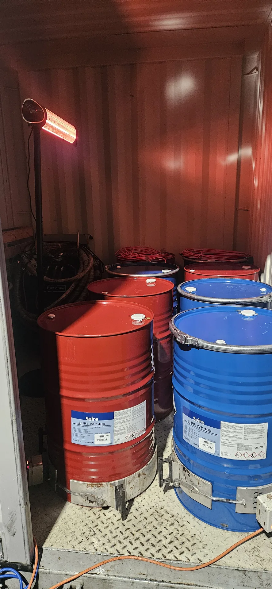 Polyurea material drums being conditioned before application